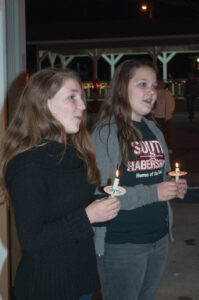 Jessica Armour, left, and Abigail Shockey sing Christmas carols during the Christmas Tree Lighting in Demorest.