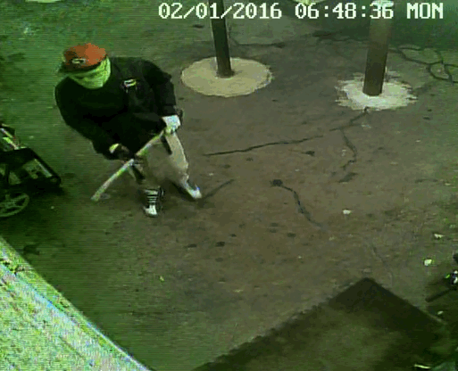 This is a still photo taken from surveillance video of one of the suspects breaking into the store with an axe.