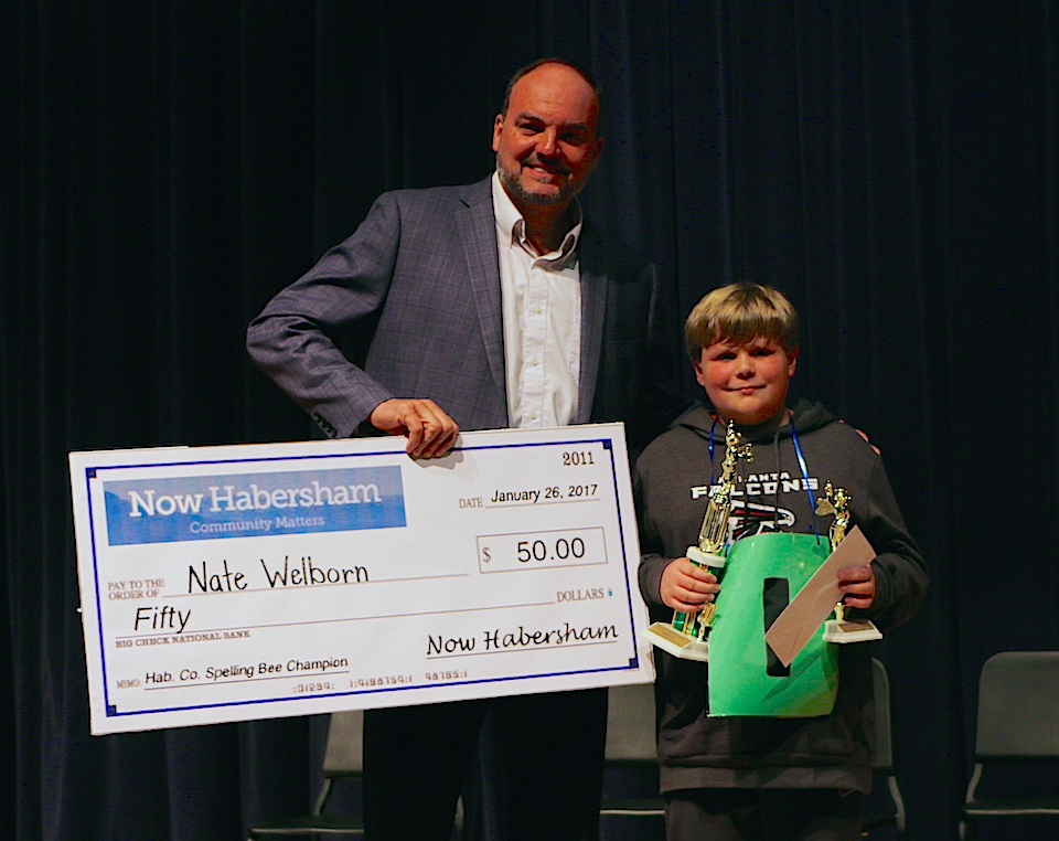 Habersham County School Superintendent Matthew Cooper presents a check from Now Habersham in the amount of $50 to this year's spelling bee runner-up, Nathaniel Welborn. Welborn is a student at Clarkesville Elementary School. (photo/Daniel Purcell)