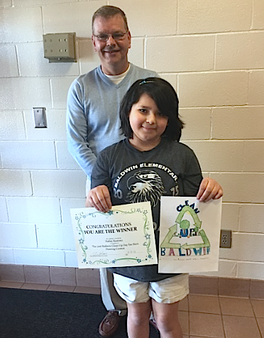 Baldwin Elementary School student Hailley Ramirez shows off her winning artwork. She's joined by Baldwin Mayor Jerry Neace.