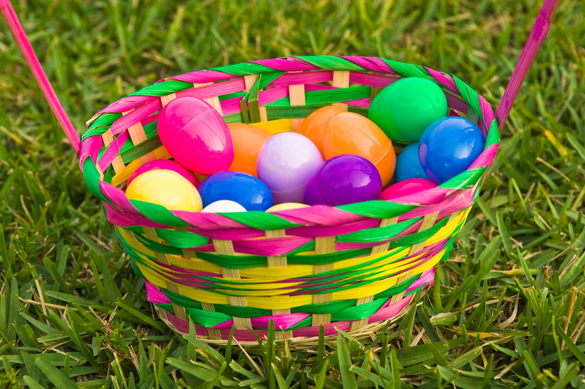 Plastic Easter eggs in basket on the grass