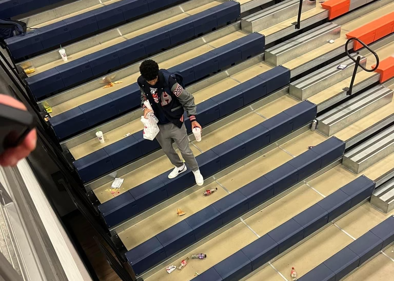 Trey King cleaning up gymnasium stands