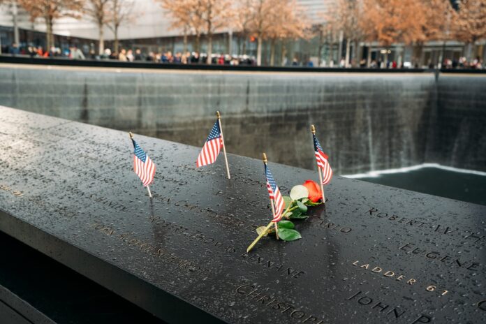 New York, United States, December 25, 2108: A Red Rose and Four U.S. Flags on the Freedom Park in New York