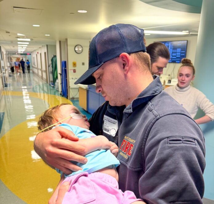 White County Firefighter Trace Swoszowski holds Ari at the hospital