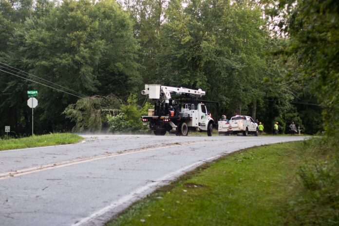 utility crews work to repair damage on Mud Creek Road
